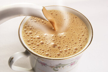 pouring milk tea into cupclose up, Cup and saucer. English tea party. Porcelain service in vintage style, sri lanka.