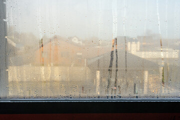 Close up of double glazed window condensation causes by excessive moisture in the house in winter occurs when the seal between panes is broken or desiccant inside the window.