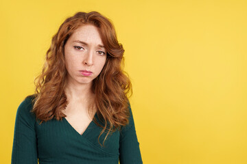 Redheaded woman looking down with sad expression