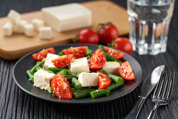 Fresh summer green beans salad bowl with tomatoes, feta, and sesame.