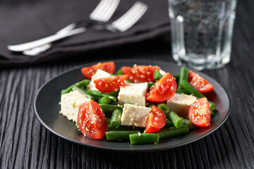 Plate with delicious green beans salad on wooden table, closeup