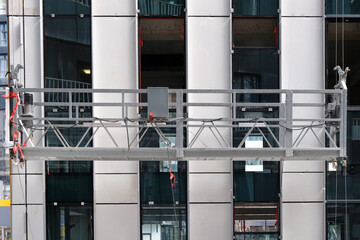 Close-up of a metal platform for workers to perform high-altitude work on the facade of the building.