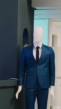 Vertical video: Modern fashionable shop with clothes on hangers, stylish brand design and formal wear in department store. Empty clothing store with fitting rooms and merchandise, commercial activity.