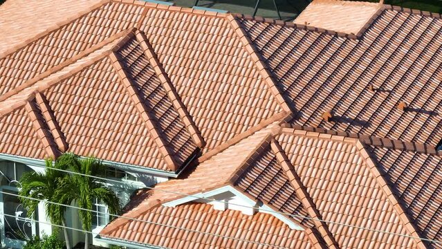 Closeup of house roof top covered with ceramic shingles. Tiled covering of building
