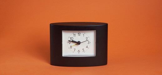 black square clock on light brown background