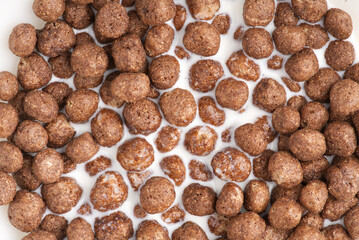 Chocolate breakfast in the form of balls in milk. Closeup
