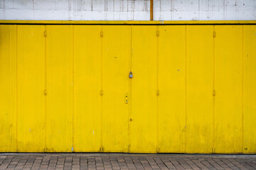 yellow metal door with wall with a padlock 