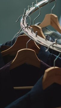 Vertical video: Empty clothes market filled with racks and hangers, modern formal wear hanging in shopping center store. Fashion boutique with shirts on discount, small business commercial activity.