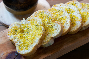 Closeups of garlic bread on chopping board.