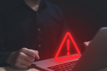 Businessman using laptop showing warning triangle and exclamation sign icon caution of dangerous...