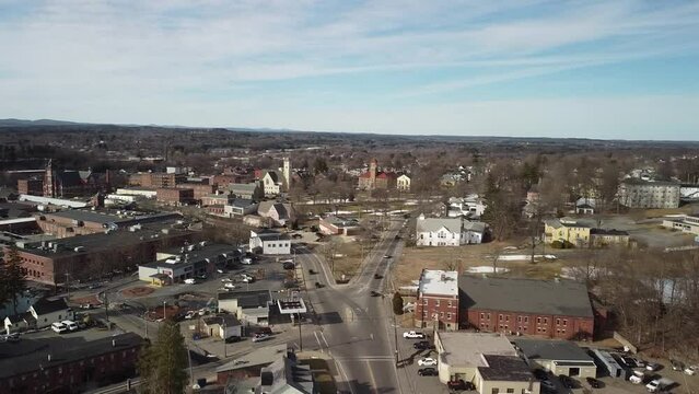 Flying over the town of Clinton, Massachusetts. Daytime main street during winter, schools and school buses, traffic.