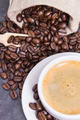 Coffee in cup and roasted dark coffee beans
