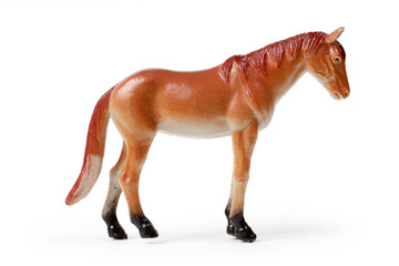 The toy horse is isolated on a white background. A figurine of a brown horse.