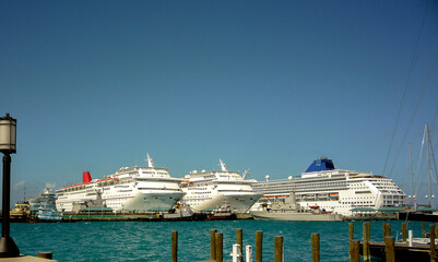 Modern cruiseship cruise ship liners line up in port of Nassau, Bahamas during mass transportation...