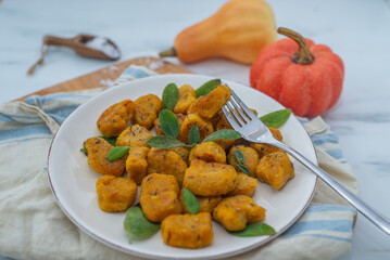 Healthy home made Pumpkin gnocchi with cheese and fresh herbs on a table