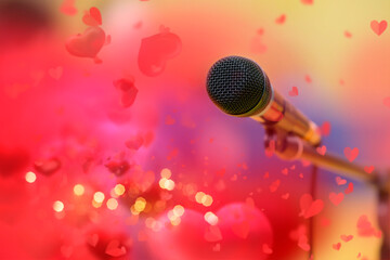 Stage golden microphone on the background of red valentine hearts and golden bokeh.
