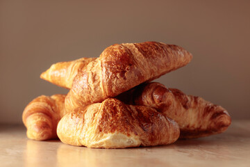Freshly baked croissants on a beige ceramic table.