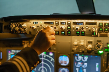 A man is studying to be a pilot in a flight simulator. Close-up of male hands on the control panel of an aircraft.