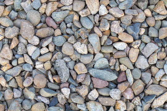 Pebbles on the sea shore as a background, pattern, texture