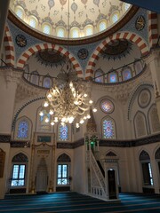 Fototapeta na wymiar Inside of the Dome of Tokyo Camii Mosque. Ceiling with crystal chandeliers in the interior of the mosque