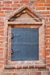 An opening in a stone house with a metal door.