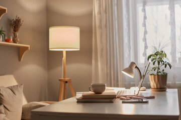 Empty workplace of modern freelancer, open laptop computer, flower in pot, smart phone, copybook on...