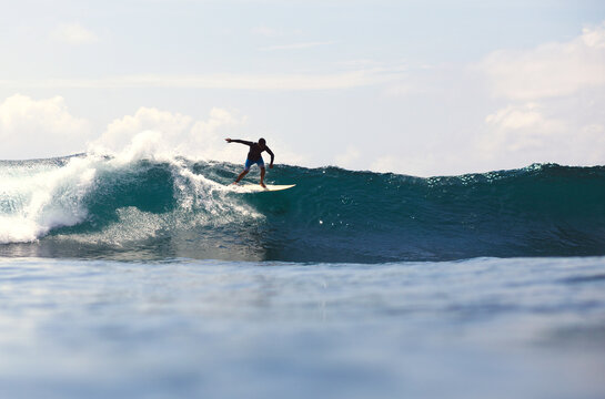 Man surfboarding in sea against sky