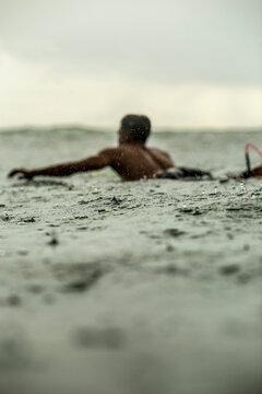 Man surfing in sea against sky during rainy season