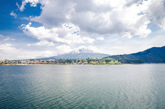 Scenic view of Mount Fuji by lake against cloudy sky