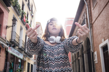 Portrait of woman showing obscene gestures while standing by buildings