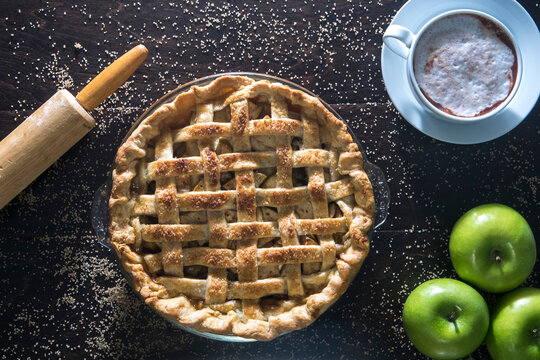 Overhead view of baked green apple pie on wooden table