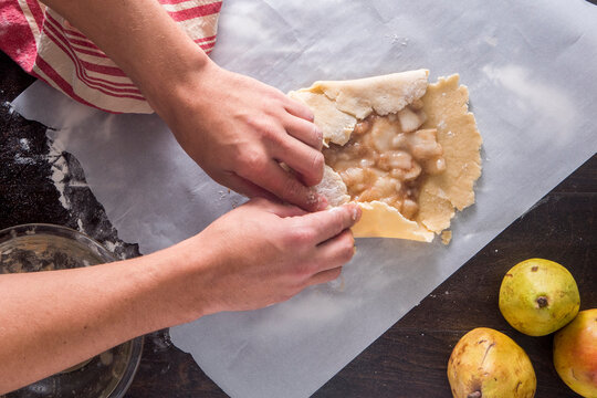 Cropped image of hands making guava tart at table