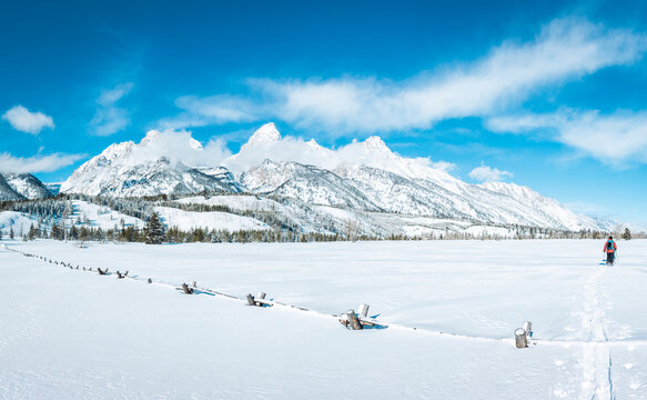 Men walking on field against snowcapped mountain