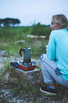 Woman looking away while preparing food on camping stove