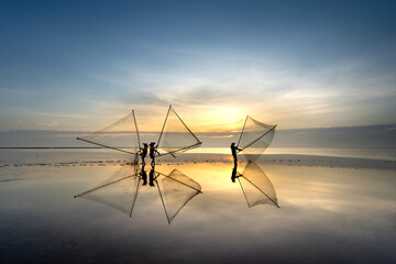 Naklejka premium The image of fishermen in fishing village using homemade tools to catch clam at sea at dawn at Diem Dien beach, Thai Thuy commune, Thai Binh province, Vietnam