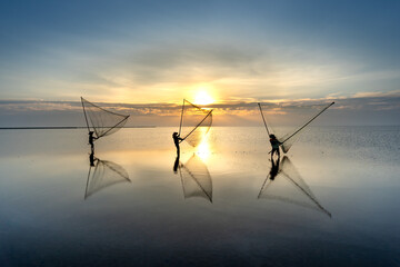 Fototapeta premium The image of fishermen in fishing village using homemade tools to catch clam at sea at dawn at Diem Dien beach, Thai Thuy commune, Thai Binh province, Vietnam
