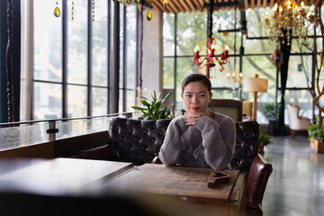 Sad tired Asian woman lonely at indoor cafe during self isolation quarantine for COVID-19 Coronavirus social distancing prevention. Mental health, anxiety depressed thinking lady.