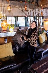 Candid lifestyle portrait of Stylish Young Asian beautiful woman sitting in modern cafe at spring or autumn season.