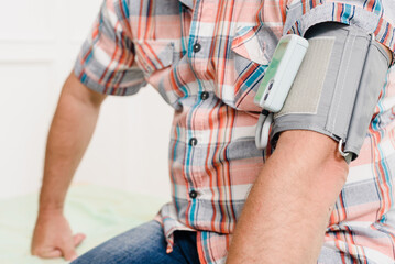 Closeup of photo of male patient checking pulse with blood pressure machine