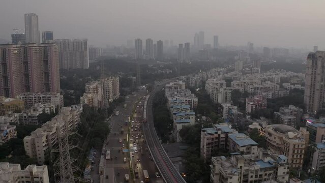 Aerial View Of Mumbai Suburban Skyline With Moving Cars On Highway Road And A Train On Railway During Rush Hour. - Aerial