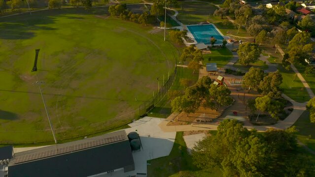 Friends practicing goal kicks in public football grounds.