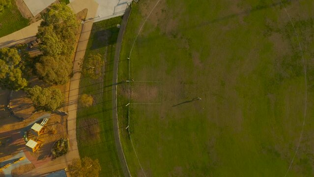 Friends kicking an AFL Australian Football to one another and missing his target by a long shot.