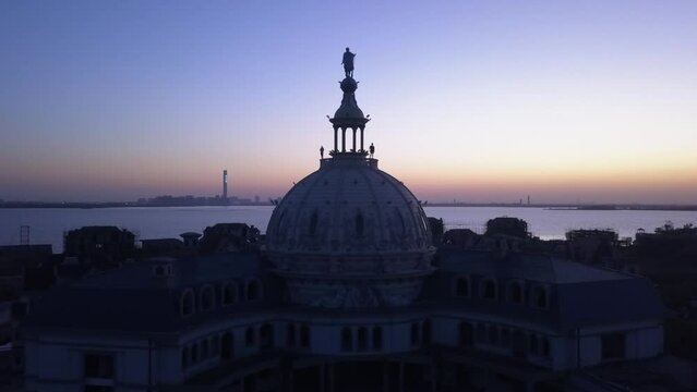 Two people silhouette against evening sky on top of dome building