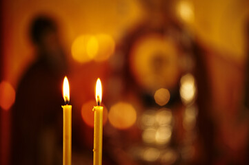 Burning church candles in a gilded candlestick in a temple.