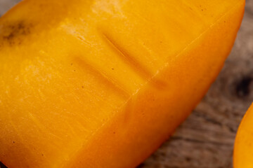 Half-ripe Orange persimmon, close up - obrazy, fototapety, plakaty