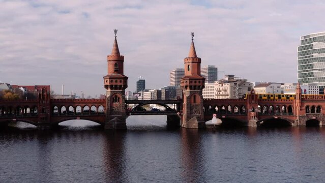 Iconic Oberbaum bridge spanning River Spree, subway train crossing over; aerial