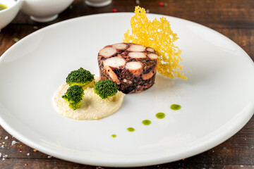Octopus terrine or octopus carpaccio with sauces on a white porcelain plate
