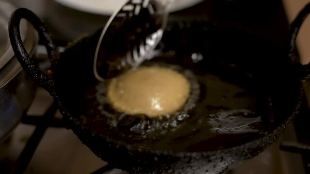 Metal Slotted Spoon Gently Turning Over Floating Fresh Guror Handesh In Pan Filled With Hot Oil