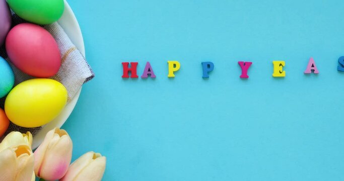 Basket with easter colored eggs, tulips and  inscription happy easter.  Looped 4K stop motion animation