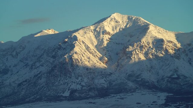 Pan down Ben Lomond Mountain  mid winter crisp cold morning Ogden Utah Wasatch Range out of focus focusing SLC